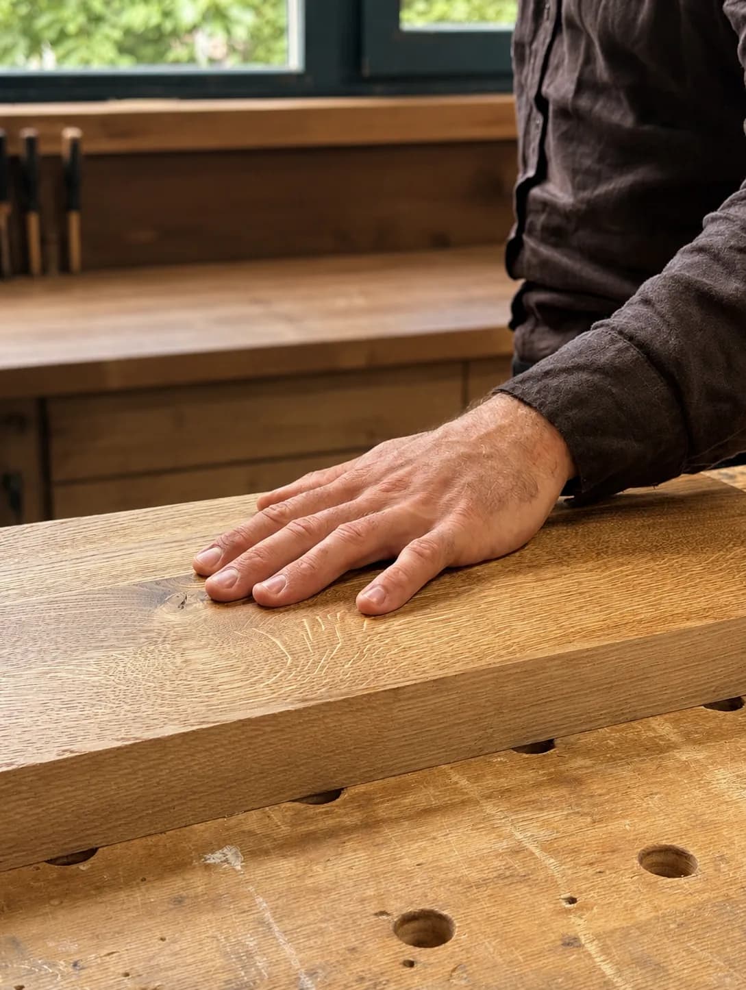 Hand streicht über eine Holzoberfläche